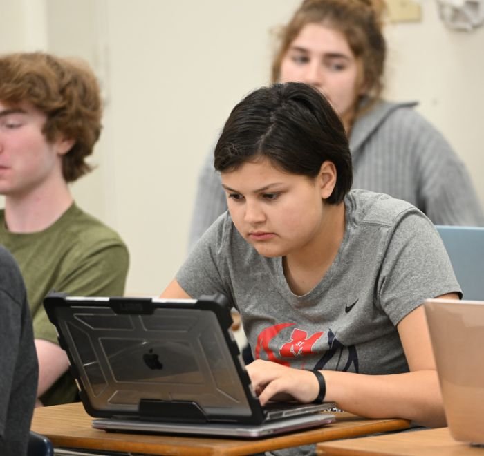 student in class working on a laptop