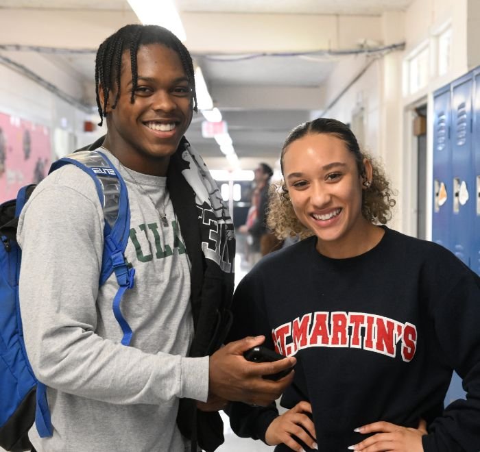 2 students in the hallway in front of blue lockers